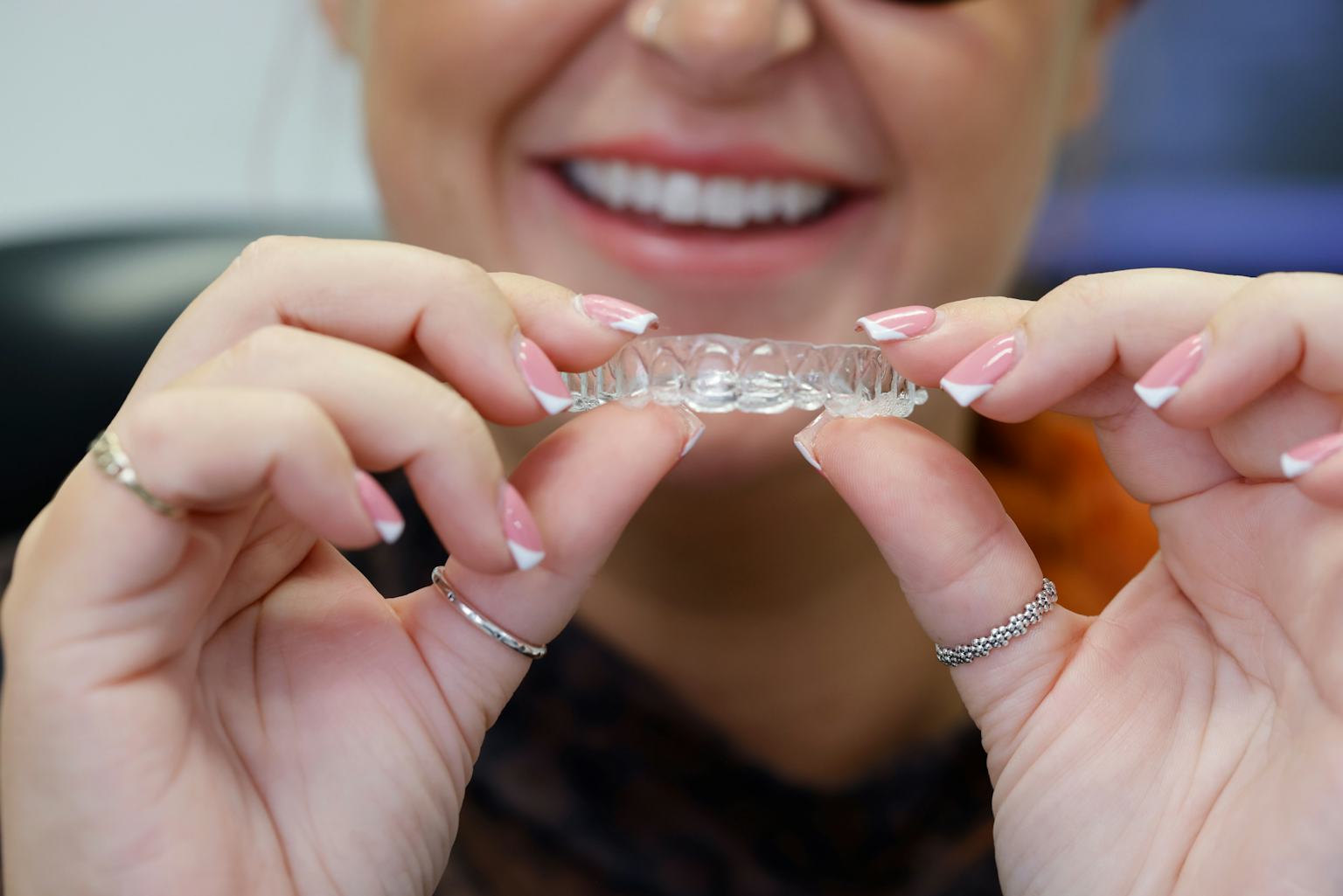 An orthodontic patient holds an Invisalign clear aligner