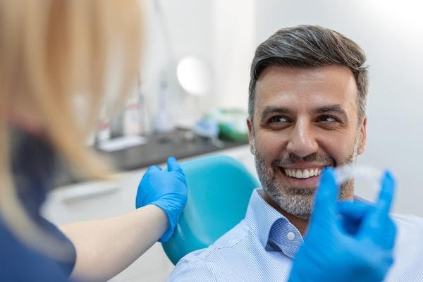 A smiling man undergoing Invisalign treatment