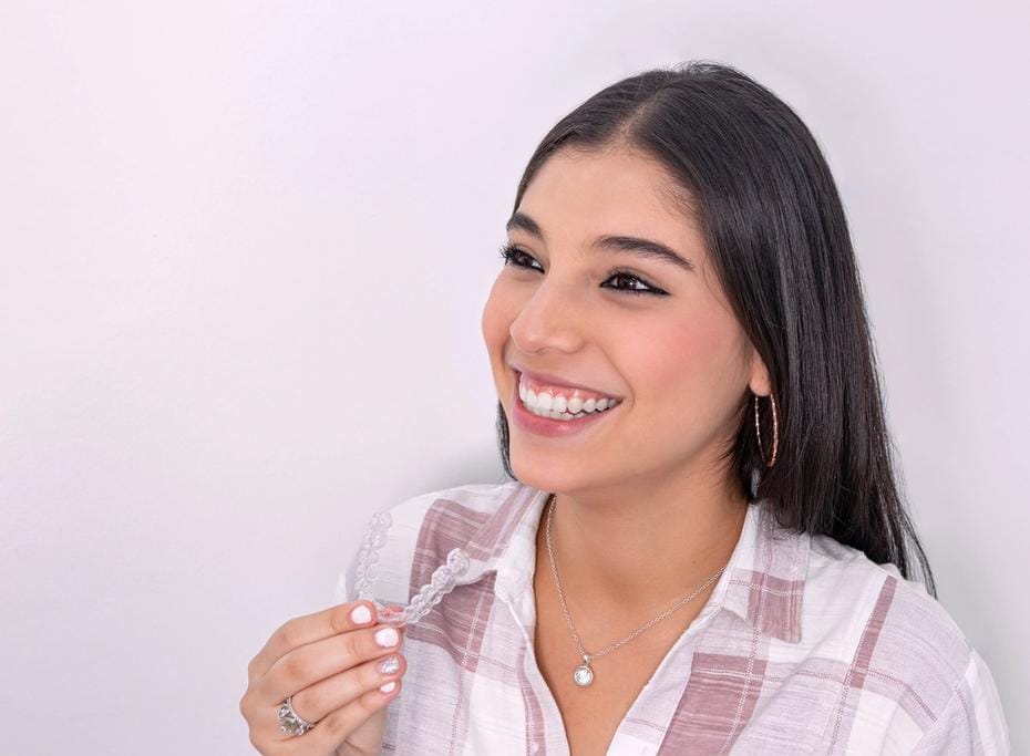 Teenage girl with Invisalign clear aligners, smiles widely