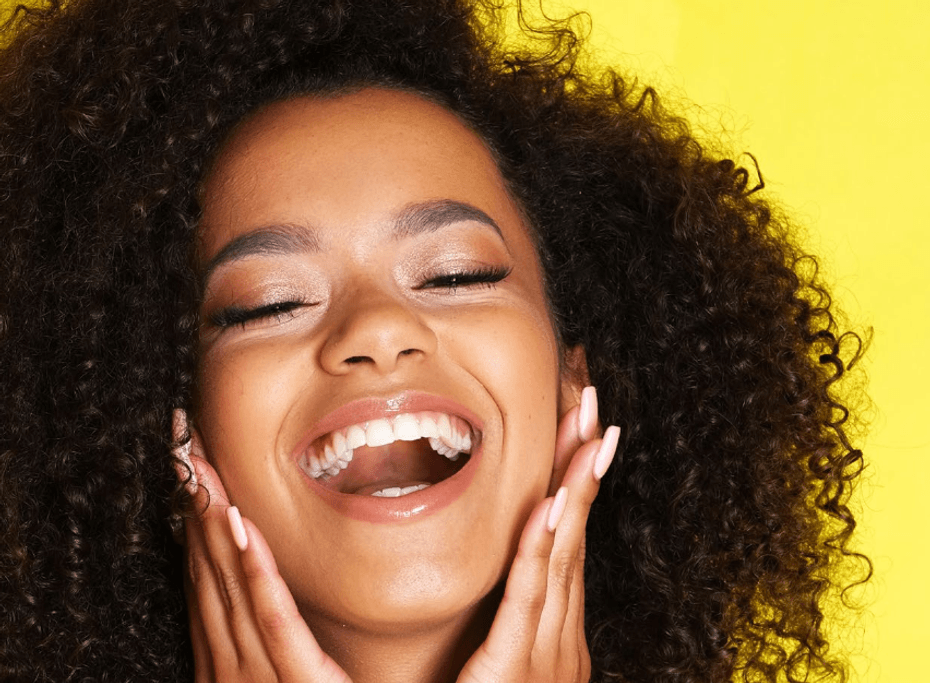 A patient shows off her white teeth and smile