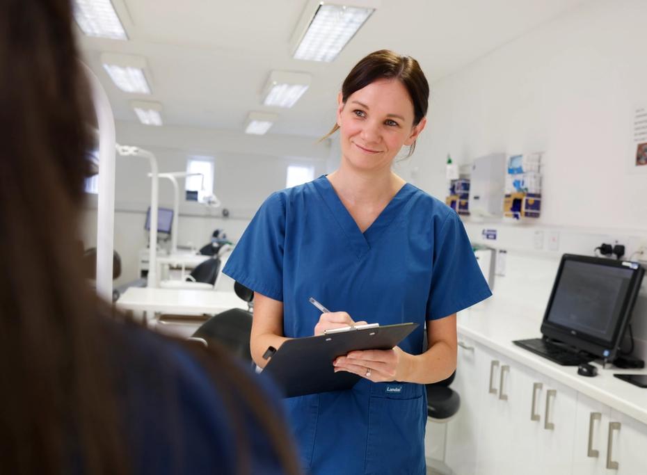 An orthodontist takes down information from a patient