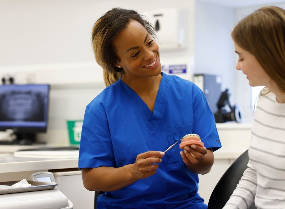 A dental professional explains NHS fixed braces to a teenager